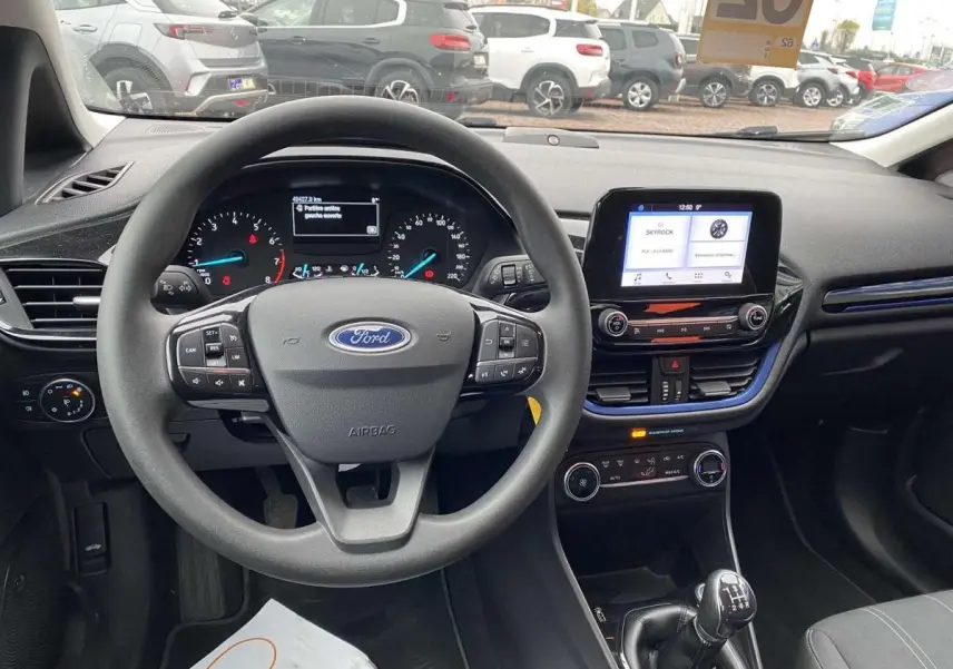 Vue intérieure avant de la Ford Fiesta bleu foncé 2017, volant multifonction et levier de vitesse manuel visible.