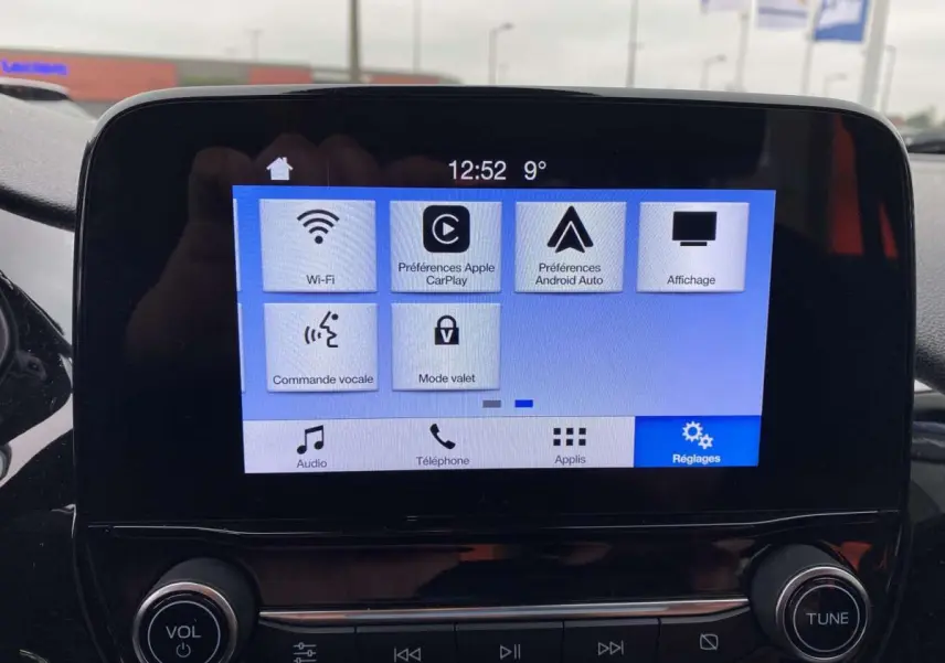Écran tactile central de la Ford Fiesta 2017 bleu foncé, affichant les réglages Wi-Fi, Apple CarPlay et Android Auto.