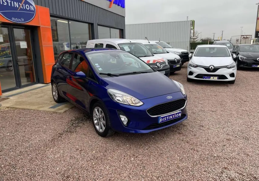 Ford Fiesta 2017 bleu foncé vue 3/4 avant droit, garée devant un concessionnaire avec plaque Distinxion.