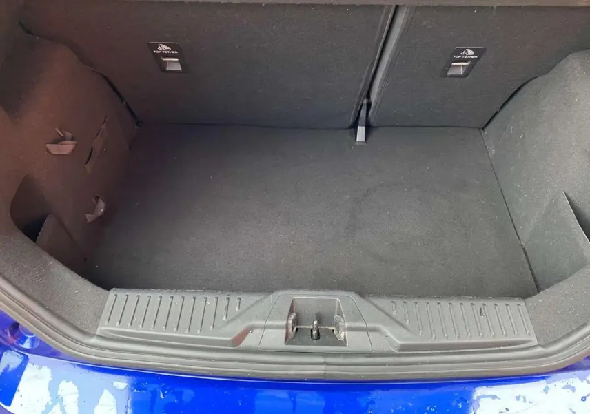 Coffre ouvert de Ford Fiesta 1.1i Trend bleu foncé, vue plongeante sur l’espace de chargement vide.