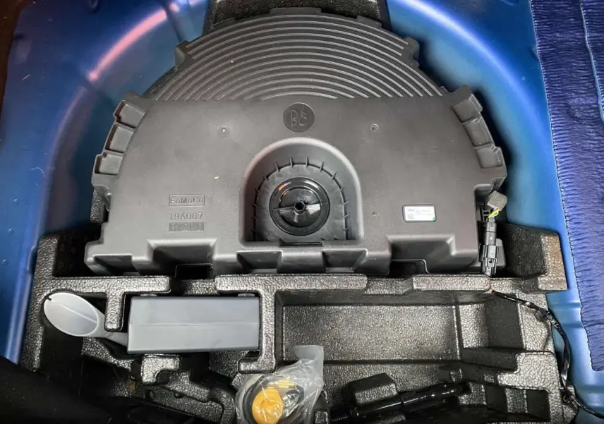 Vue plongeante sur le coffre d’une Ford Fiesta bleu foncé 2017, montrant le rangement sous la roue de secours.