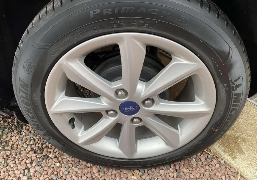 Gros plan sur la jante alliage argentée et pneu Michelin d’une Ford Fiesta bleu foncé, version Trend 2017.