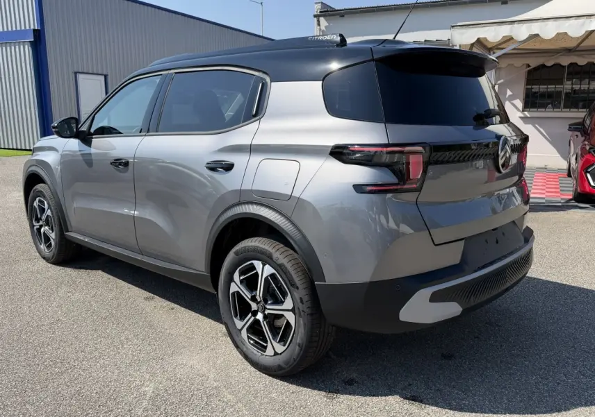 Citroën C3 Aircross gris clair vue 3/4 arrière droit, toit noir et jantes distinctives, stationnée en extérieur.
