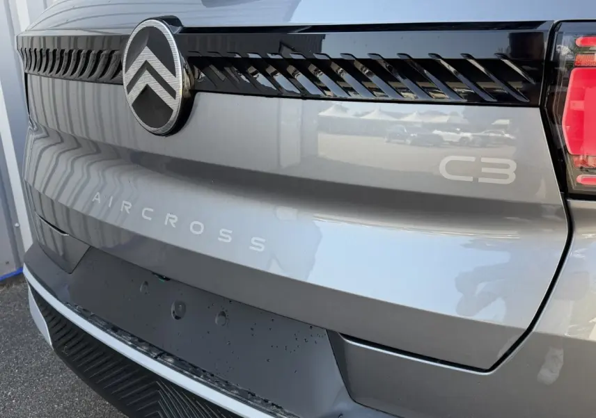 Gros plan arrière droit du Citroën C3 Aircross gris clair avec logo et lettrage distinctifs sur le hayon.