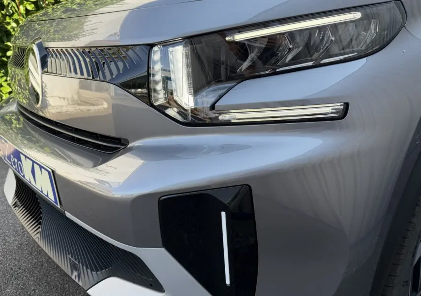 Gros plan sur l’avant droit gris clair du Citroën C3 Aircross 2026, mettant en valeur le phare LED et la calandre distinctive.