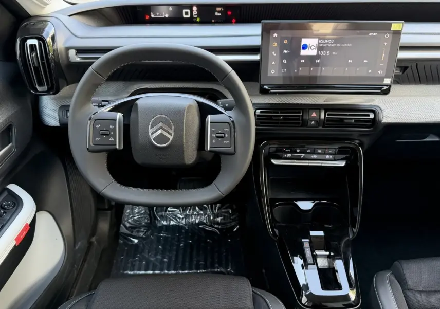 Vue intérieure avant du Citroën C3 Aircross gris clair, volant cuir multifonctions et grand écran tactile central.