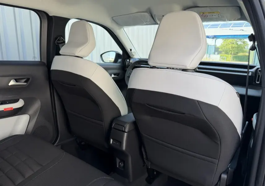 Vue arrière intérieure des sièges avant bicolores noir et blanc du Citroën C3 Aircross gris clair 2026 hybride.