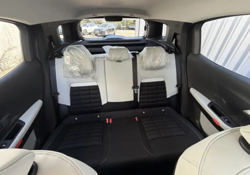 Vue intérieure arrière de la banquette bicolore noire et blanche du Citroën C3 Aircross 2026 avec appuis-tête protégés.