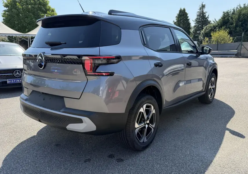 Vue 3/4 arrière droite d'un Citroën C3 Aircross gris clair avec toit noir et feux arrière LED distinctifs.