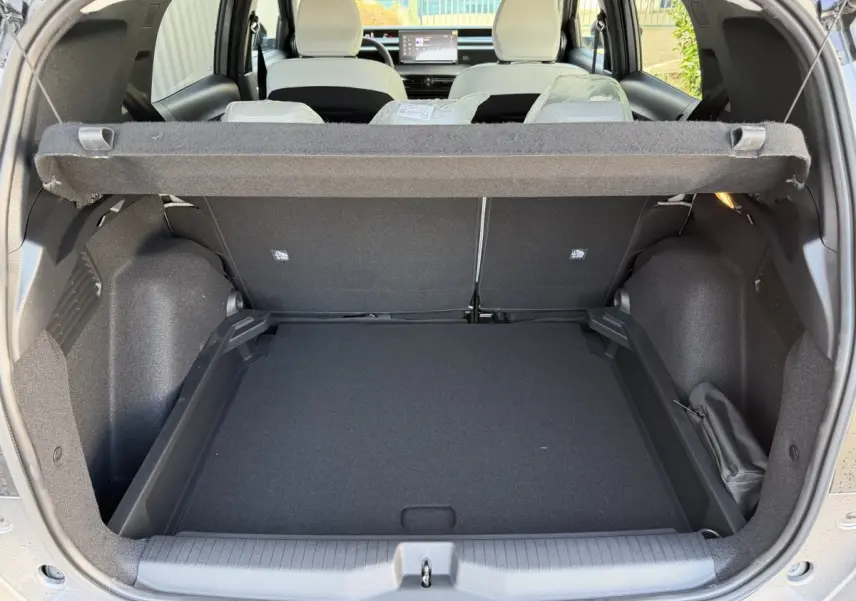 Coffre ouvert vu de l'arrière d'un Citroën C3 Aircross gris clair avec banquette arrière et tableau de bord visible.