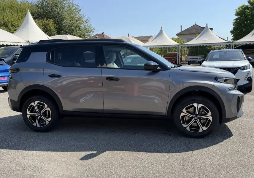 Profil côté gauche d'un Citroën C3 Aircross gris clair 2026 avec toit noir et jantes distinctives bicolores.