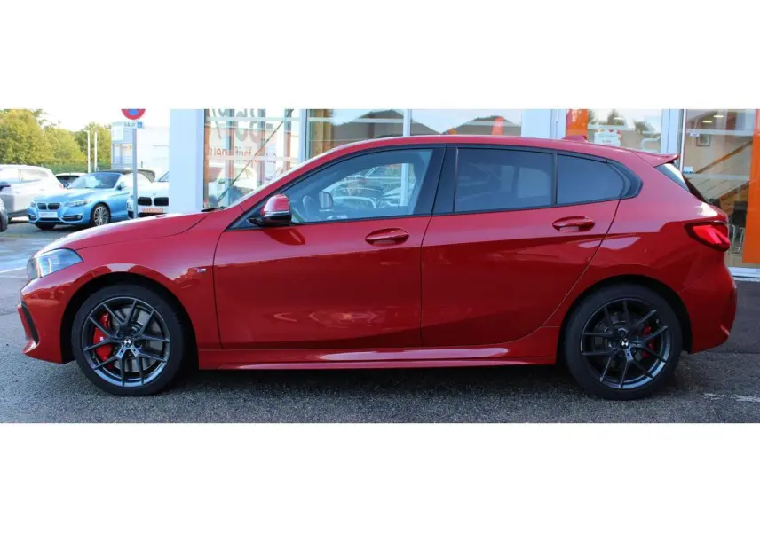 Vue de profil côté gauche d'une BMW Série 1 118d Edition M Sport Pro rouge Melbourne métallisé avec jantes alliage et freins rouges M.