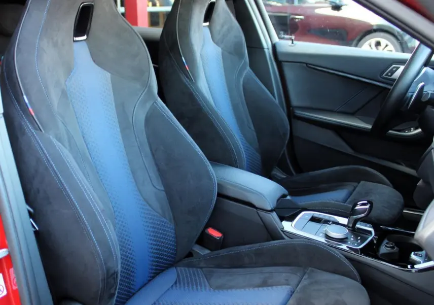 Intérieur BMW Série 1 118d 2022, vue côté droit sur sièges M Sport en tissu Trigon Alcantara noir et bleu.