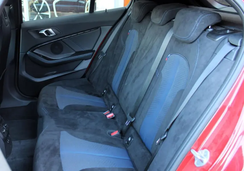 Vue intérieure côté gauche des sièges arrière en tissu Alcantara noir et bleu d'une BMW Série 1 118d Melbourne Rot.