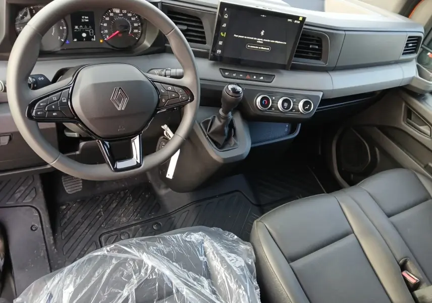 Vue intérieure du poste de conduite du Renault Master 2026, avec volant multifonction, boîte manuelle et écran tactile central.