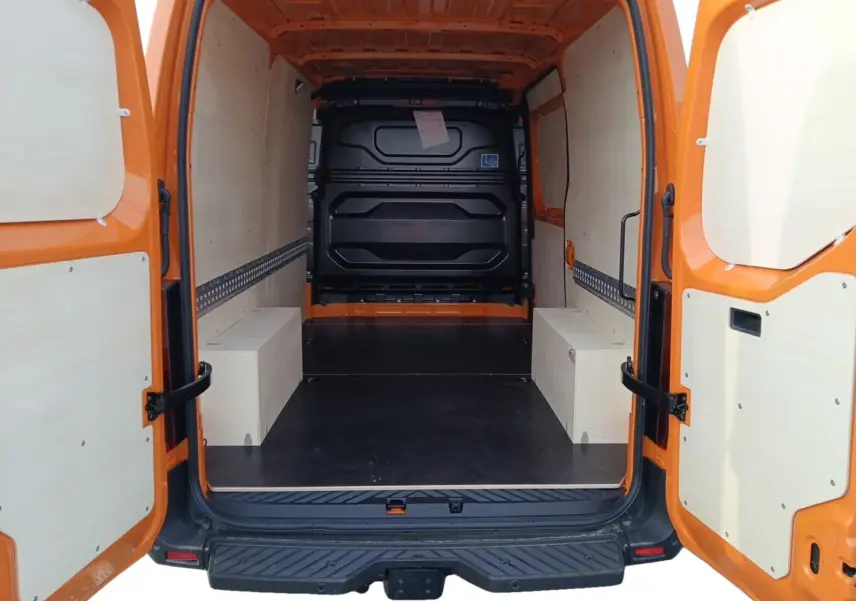 Vue arrière ouverte du Renault Master L2H2 3T5 orange, montrant l’espace de chargement avec aménagements bois clairs.