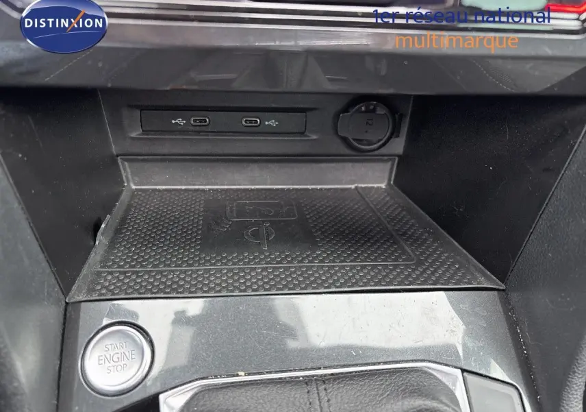 Détail de la console centrale du Volkswagen Tiguan 1.4 E-Hybrid 2022 avec bouton start/stop et zone de recharge sans fil.