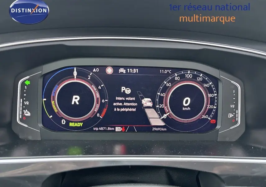 Tableau de bord numérique du Volkswagen Tiguan hybride rechargeable 2022 affichant la vitesse, régime et alertes au centre.