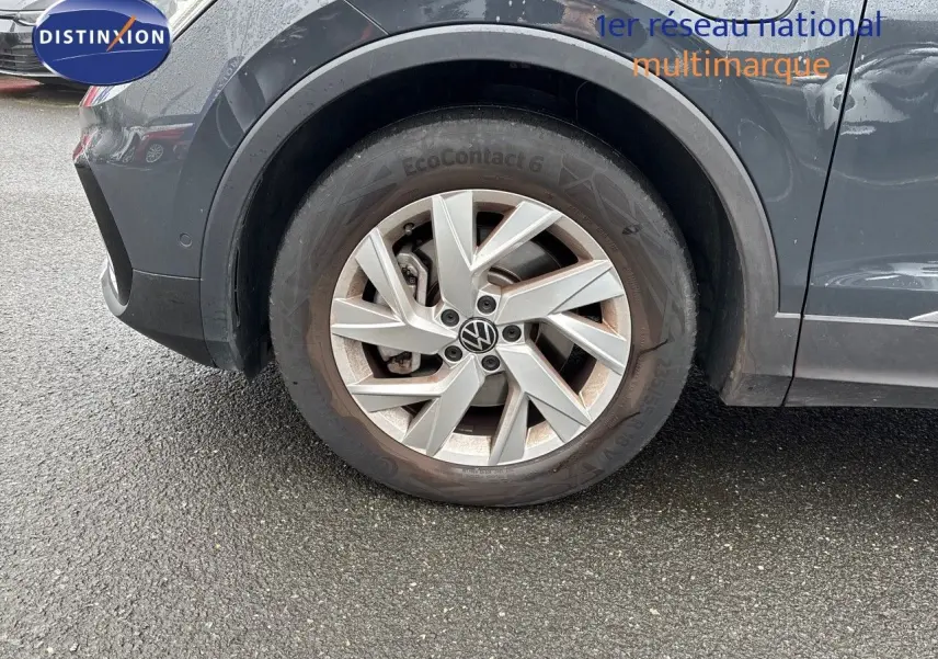 Gros plan sur la roue avant gauche du Volkswagen Tiguan gris lunaire, mettant en valeur la jante alliage et le pneu EcoContact 6.