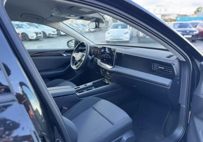 Intérieur avant droit de la Volkswagen Passat SW noire 2024, avec tableau de bord numérique et écran tactile central.