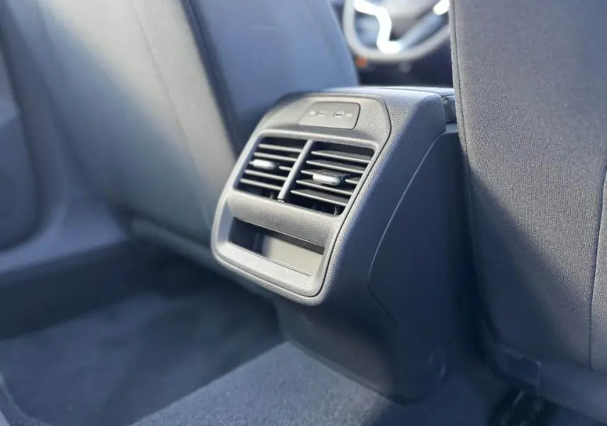 Vue rapprochée de la console arrière noire avec bouches d’aération et ports USB dans une Volkswagen Passat SW 2024.