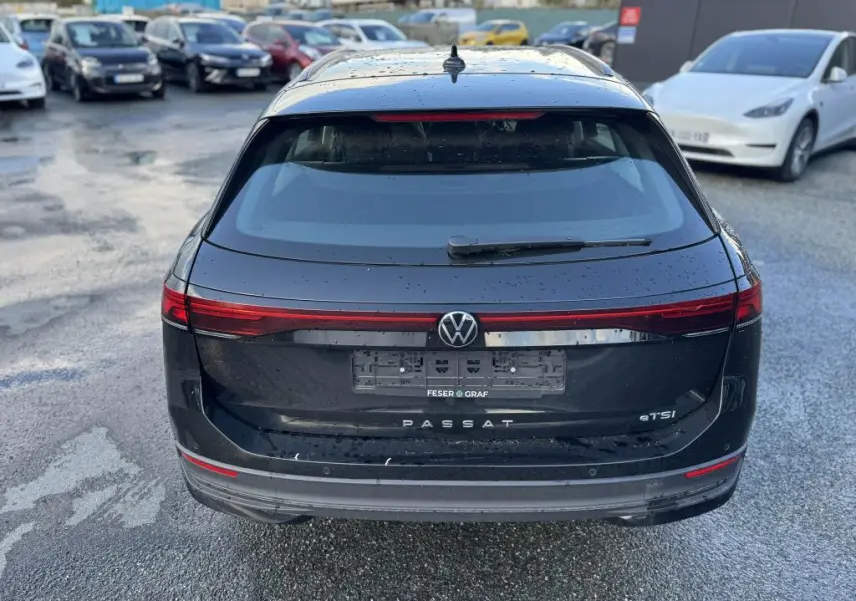 Vue arrière d'une Volkswagen Passat SW noire 2024 avec feux arrière LED et logo VW centré sur le hayon.