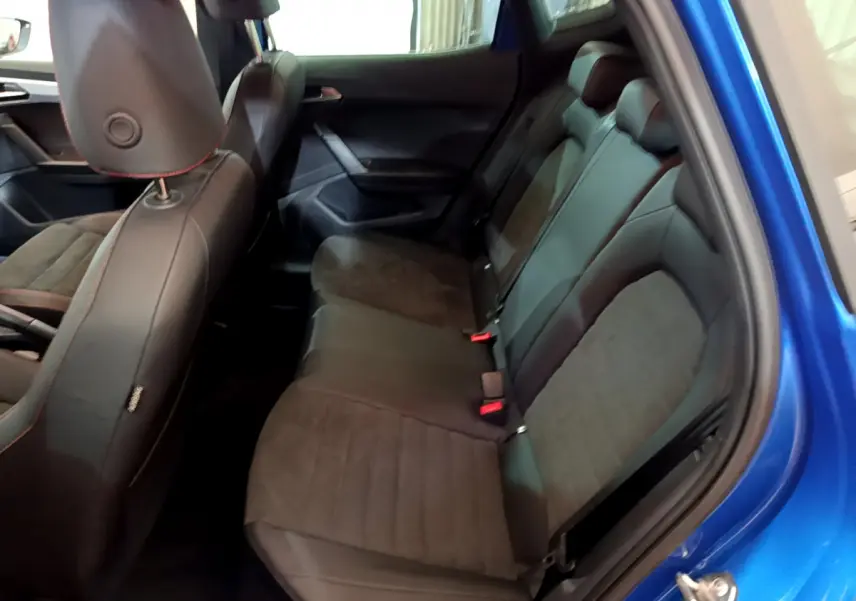 Vue intérieure côté droit sur la banquette arrière en tissu et cuir noir du SEAT Arona bleu 2022.