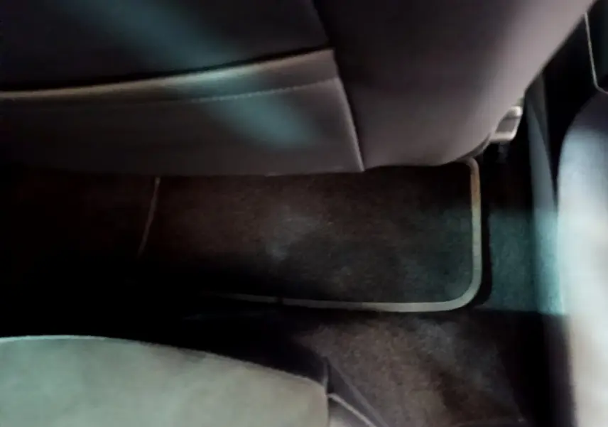 Vue intérieure en plancher arrière côté passager du SEAT Arona 2022, moquette noire et siège en cuir sombre.