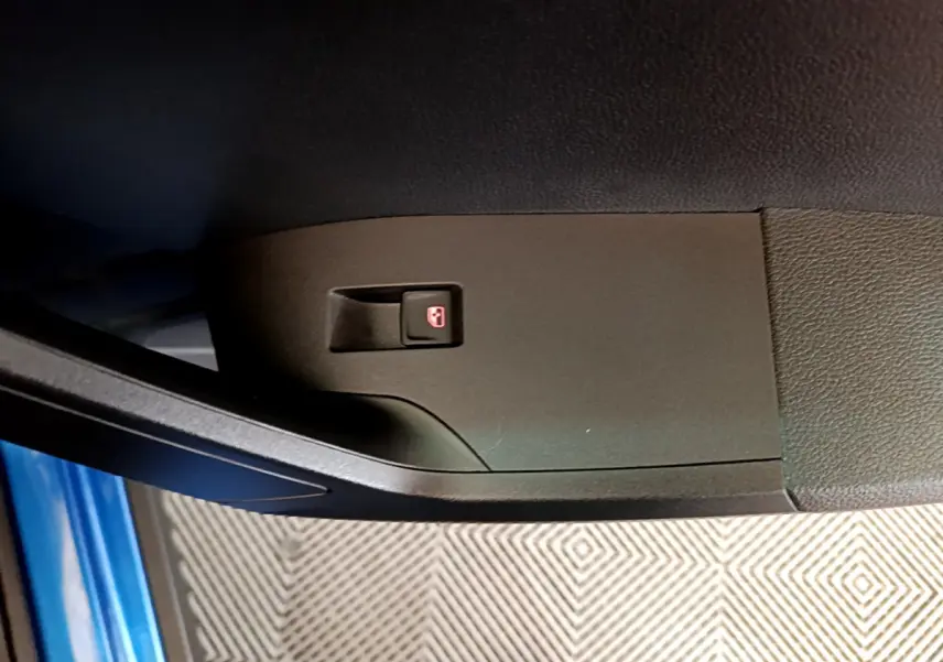 Bouton de verrouillage des portes sur la portière côté conducteur d'un SEAT Arona bleu 2022, vue rapprochée.