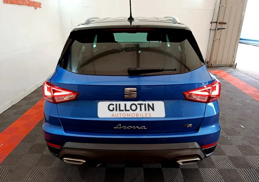 Vue arrière d'un SEAT Arona bleu 2022 finition FR avec feux LED et double sortie d'échappement.