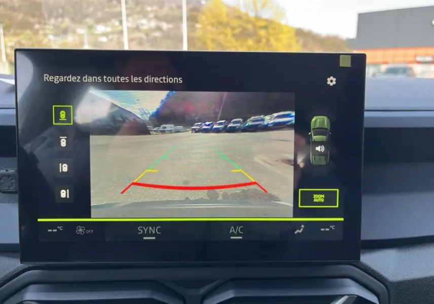 Écran de caméra multiview affichant la vue arrière du Dacia Bigster gris schiste, intérieur tableau de bord moderne.