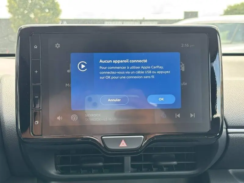 Écran tactile central de la Toyota Yaris 116h Dynamic 2025, affichant un message de connexion Apple CarPlay, intérieur noir.