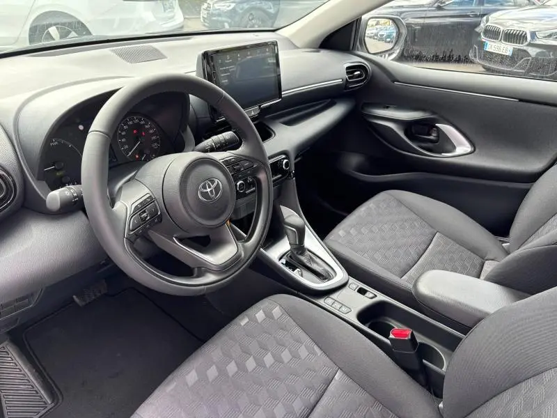 Vue intérieure côté conducteur de la Toyota Yaris 116h Dynamic 2025 avec tableau de bord moderne et écran tactile central.