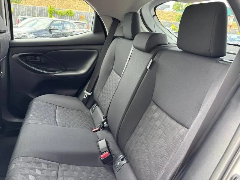 Vue intérieure sur les sièges arrière noirs de la Toyota Yaris 116h Dynamic 5p MC24 blanche, avec ceinture de sécurité visible.