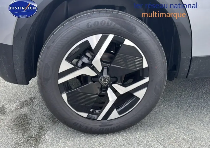 Gros plan sur la roue avant droite avec jante alu bicolore du Peugeot 2008 gris artense.