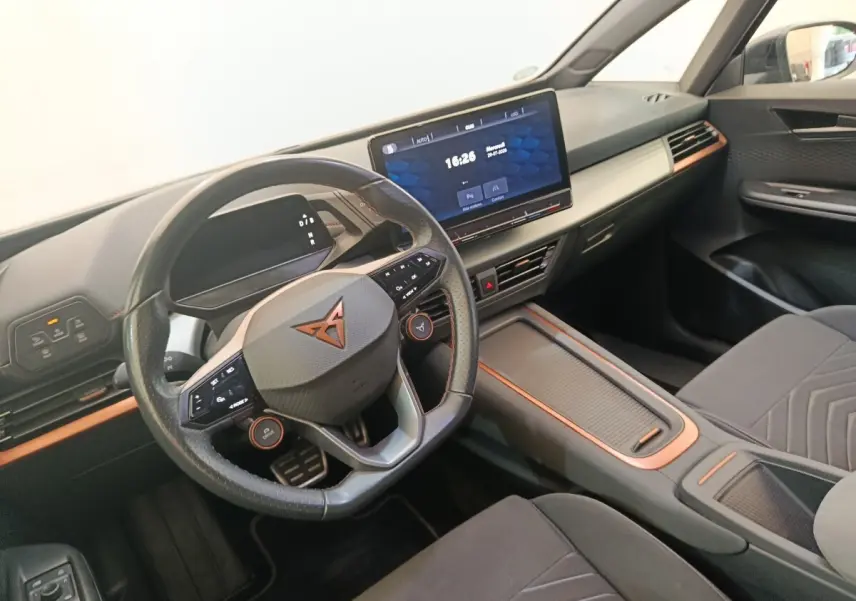 Vue intérieure côté conducteur du CUPRA BORN 230ch 2023, volant cuir avec inserts cuivrés et écran tactile central 12 pouces.