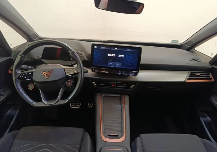 Vue intérieure avant du tableau de bord et volant cuir noir avec logo CUPRA, écran tactile central 12 pouces, détails cuivre.