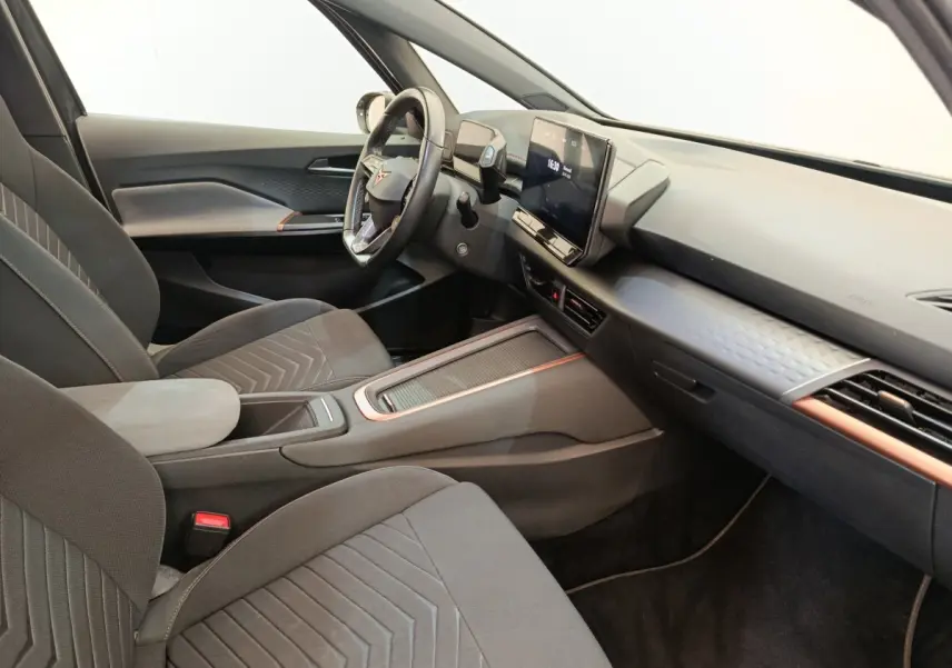Intérieur côté conducteur du CUPRA Born gris foncé 2023, avec tableau de bord moderne et écran tactile central.