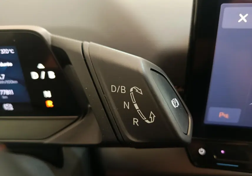 Gros plan sur la commande de boîte automatique D/B, N, R avec bouton frein à main électronique dans un CUPRA BORN gris foncé.