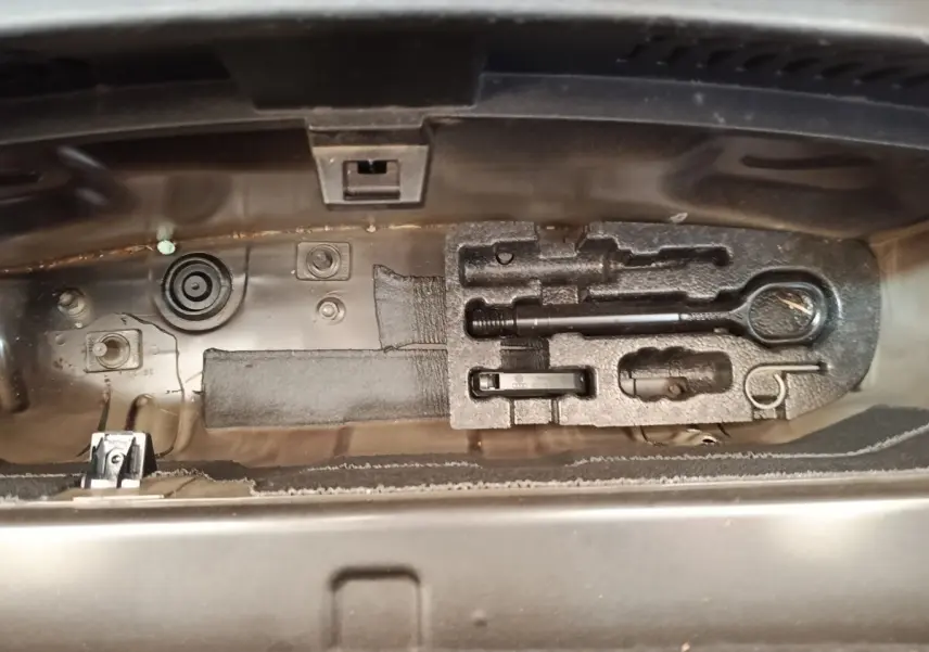 Vue rapprochée de la trousse à outils noire dans le coffre du CUPRA BORN gris foncé 2023.
