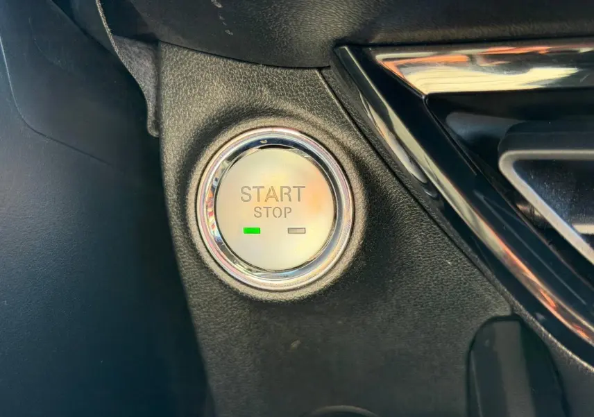 Détail du bouton Start/Stop entouré de chrome dans l'habitacle noir du MG3 1.5 Hybrid+ 2025.