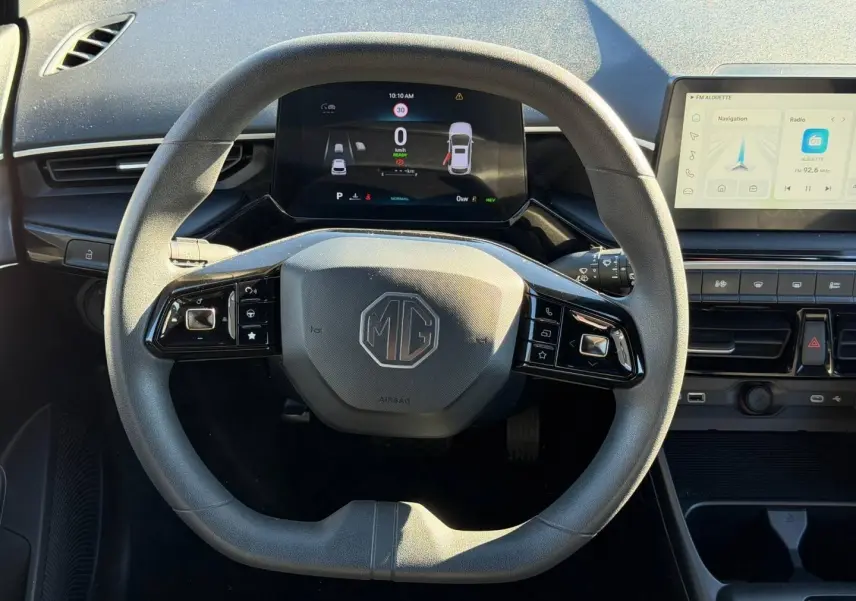Vue frontale du volant noir multifonction MG3 1.5 Hybrid+ avec tableau de bord numérique et écran tactile latéral.
