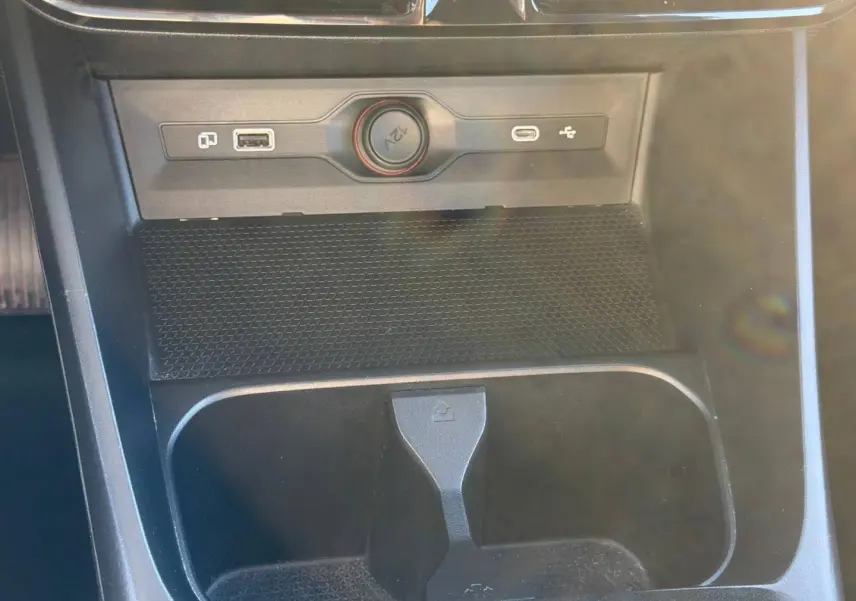Gros plan sur la console centrale noire du MG3 1.5 Hybrid+ 2025 avec prise 12V et ports USB visibles.