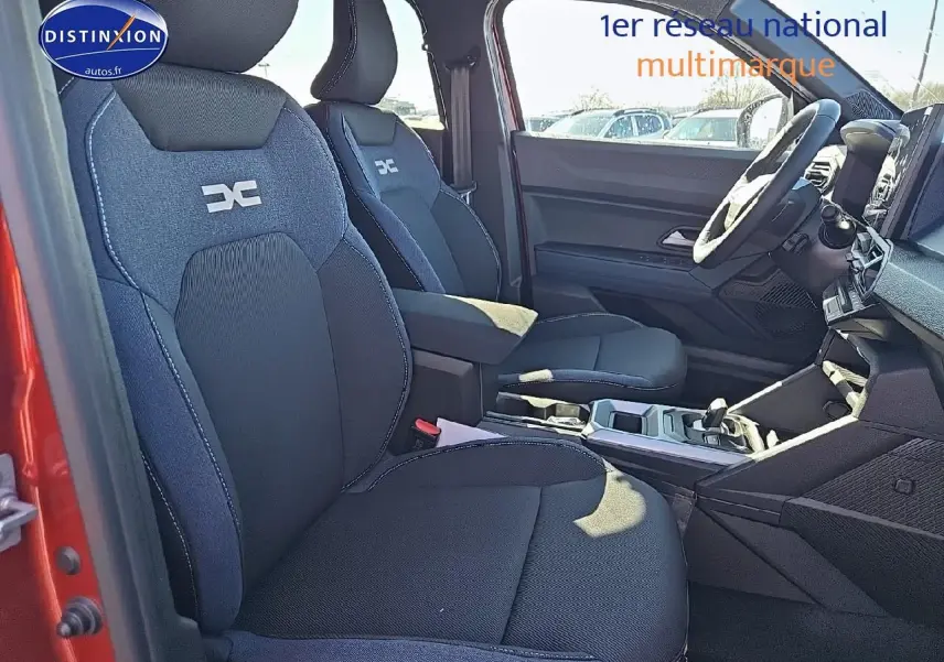 Vue intérieure côté gauche du Dacia Duster 2025 brun terracotta, mettant en valeur les sièges avant et le tableau de bord.
