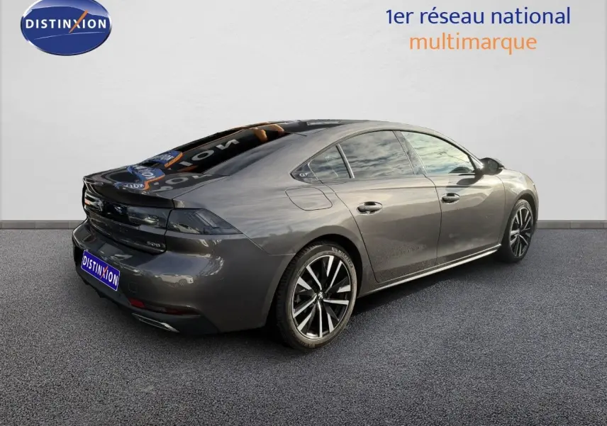 Peugeot 508 gris platinium vue 3/4 arrière droit, avec jantes alliage noires et vitres teintées.