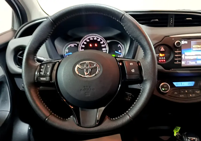 Vue centrée sur le volant cuir noir de la Toyota Yaris 1.5 Hybride 2020 avec tableau de bord et écran tactile visible.