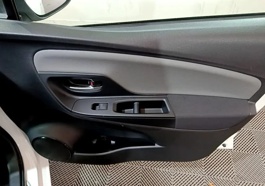 Vue rapprochée de la porte avant gauche intérieure noire et grise de la Toyota Yaris blanche 2020 hybride.