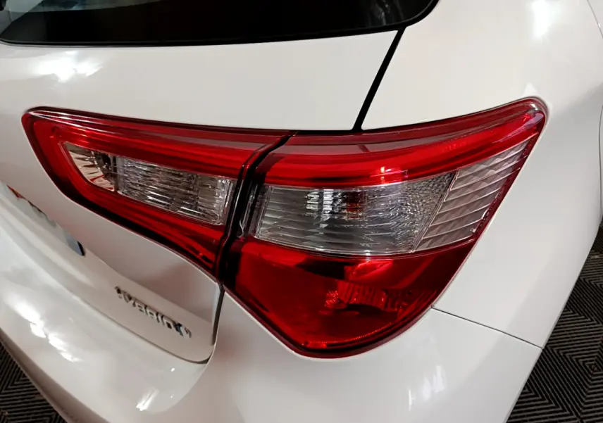 Gros plan sur le feu arrière droit rouge et blanc d'une Toyota Yaris blanche, version hybride 2020.