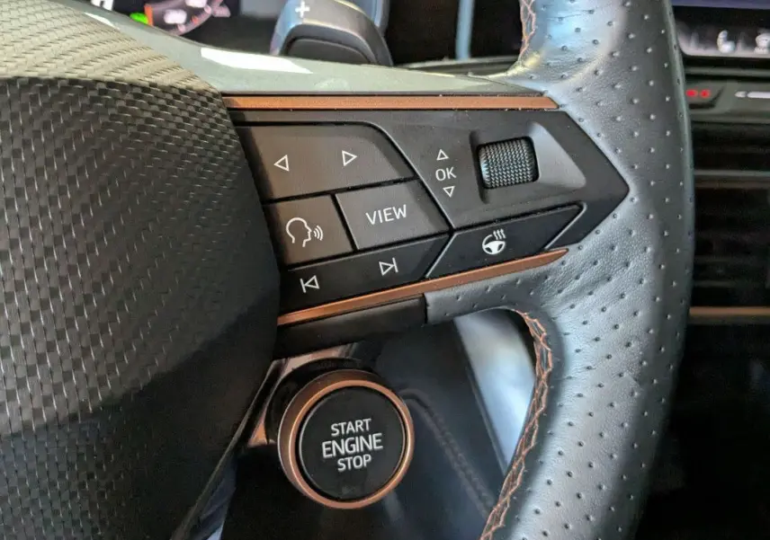 Gros plan sur le volant perforé noir du Cupra Formentor 2025 avec commandes multifonctions et bouton start/stop.