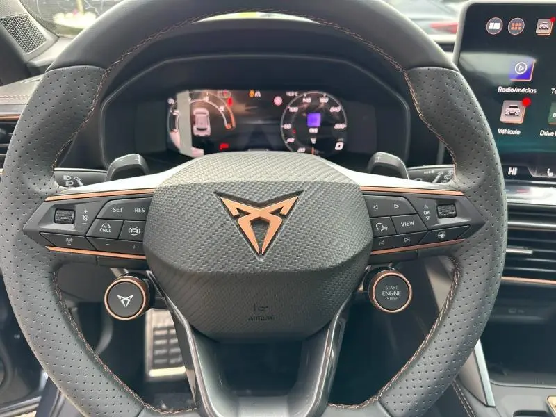Vue rapprochée du volant sport en cuir perforé noir avec logo CUPRA cuivré et commandes multifonctions intégrées.